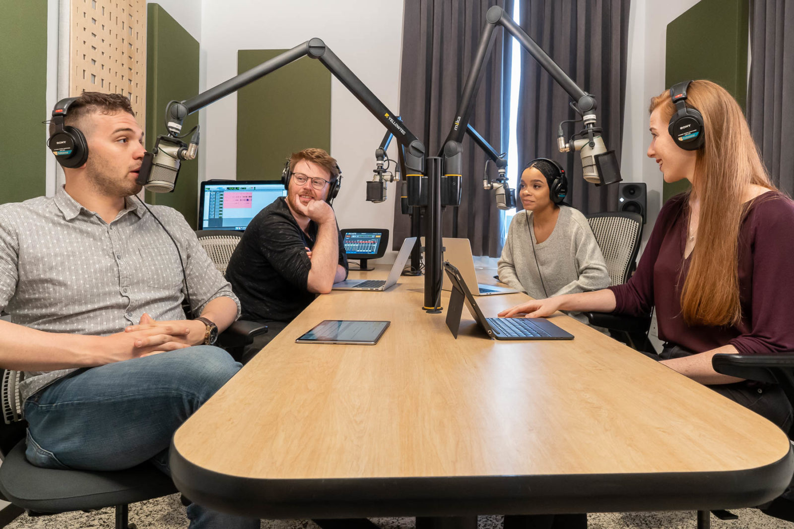 4 people recording a podcast in a sleek studio space