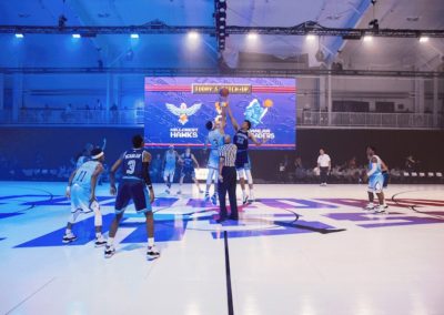 Basketball court with lights and people playing basketball